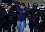 Forbundspoliti med Arnoldo Rueda Medina, et angiveligt højtstående bandemedlem i narkokartellet La Familia. Anholdelsen af Medina  førte til dødelige angreb fra narkobanden på mexicansk forbundspoliti og soldater. Ind til videre er syv døde. 