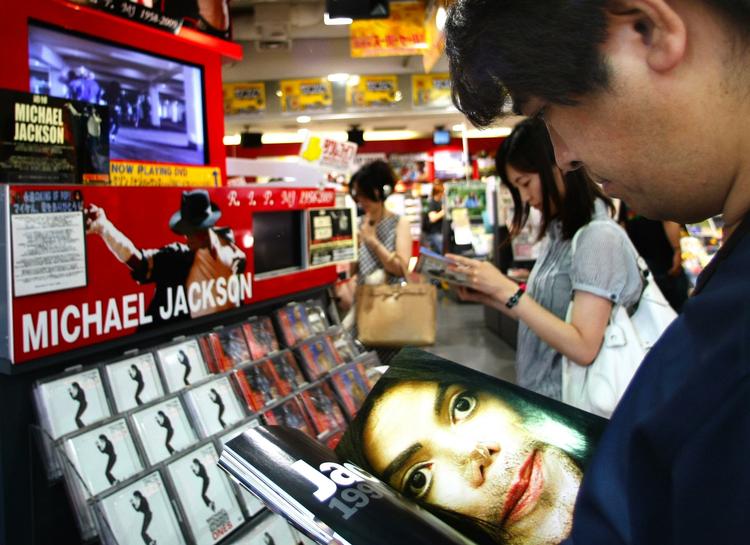 En japansk mand bladrer i en Michael Jackson-bog under et besøg  i en pladeforretning i Tokyo. Om kort tid vil hylderne være fulde af nye bøger om den afdøde popkonge. Arkivfoto. 