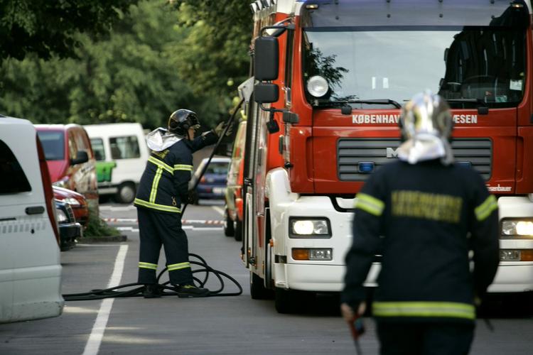 Brandfolk er ankommet til stedet og har rullet slanger ud. 