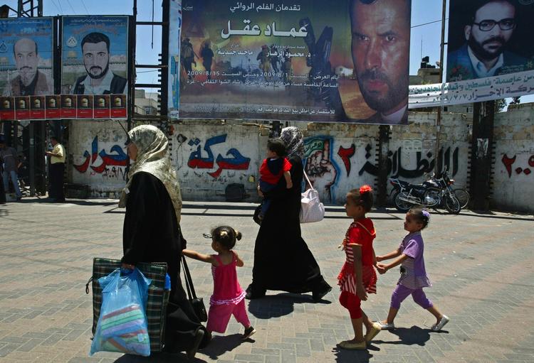 Palæstinensere går forbi plakaten for Hamas' første spillefilm, 'Emad Akel'. 
