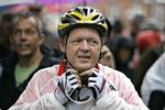 Statsministeren iført Dannebrogs-farvet cykeltøj og regnfrakke første dag af cykelturen til Paris. 