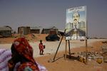 Indbyggere i kvarteret Hay Sakin i Mauretaniens hovedstad Nouakchott går forbi en valgplakat for kupgeneralen Mohamed Ould Abdel Aziz, der vandt weekendens valg. 