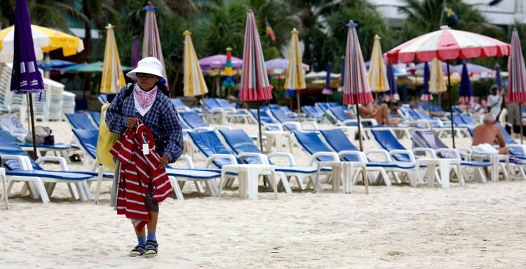 En lokal sælger søger kunder på Patong stranden i Phuket, Thailand. Lønforskellene på turister og indfødte er enorm. Arkivfoto 