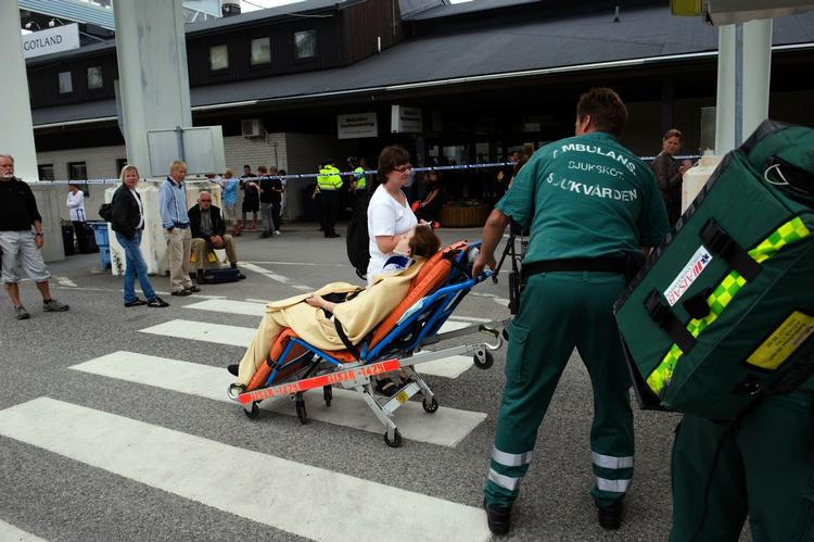 En tilskadekommen passager køres væk, efter at skibene er kommet i havn. 