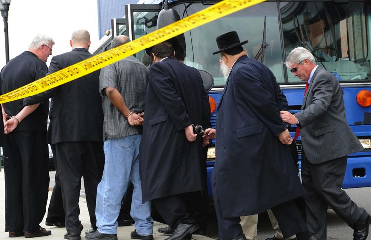 Rabbinere bliver ført væk efter FBI's anholdelser. 