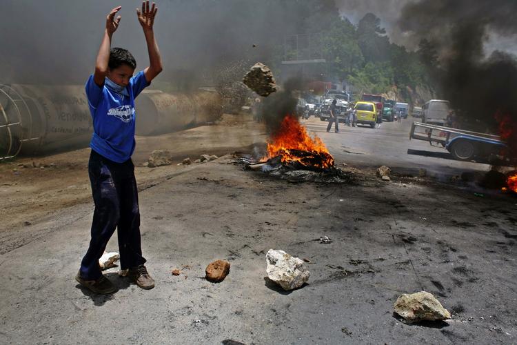En dreng deltager torsdag i en demonstration til fordel for Honduras' afsatte præsident, Manuel Zelaya. Fire uger efter kuppet raser protesterne stadig, og en ny rapport viser, at kupregeringen i ly af uroen har likvideret politiske modstandere. 