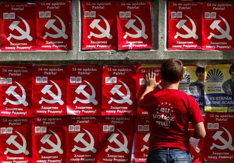 En arbejder sætter plakater for kommunisterne op i Chisinau i Moldova. På plakaterne står der »Lad os forsvare fædrelandet«. 