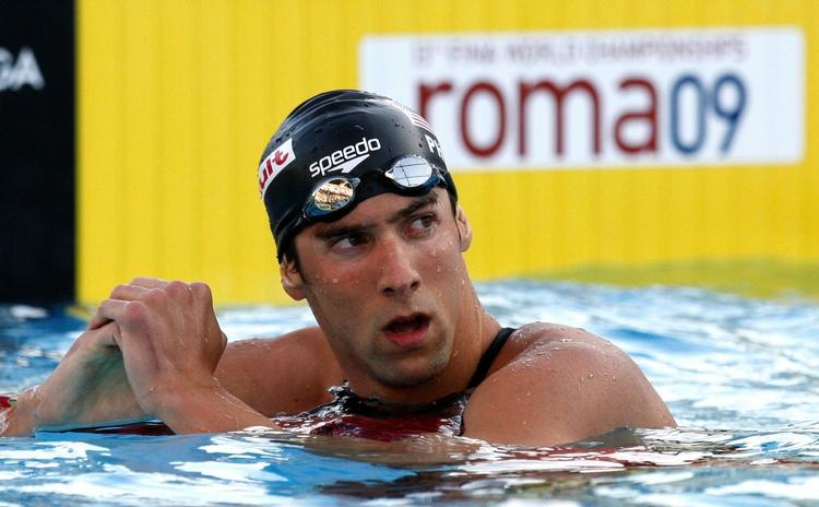 Efter nederlaget i 200 meter fri, truer amerikanerens træner med, at Michael Phelps ikke vil svømme igen, før der kommer orden i Fina's regler. 