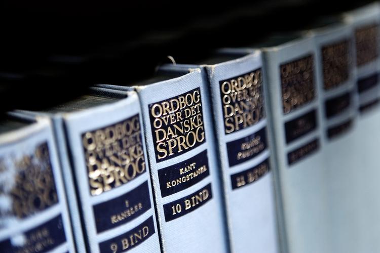 Ordbog Over Det Danske Sprog rummer definitionen og baggrunden for en kvart million danske ord  og ordsammensætninger og fylder halvanden hyldemeter. Heldigvis er værket også at finde på Sproget.dk. 