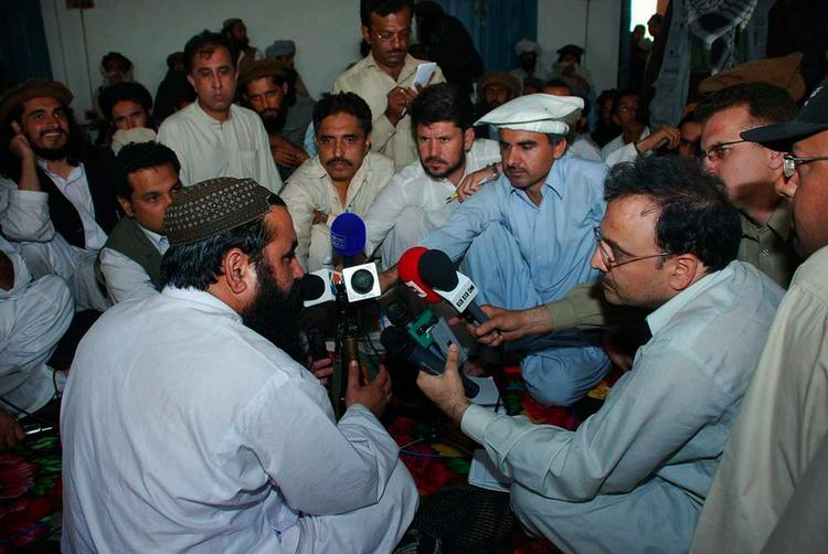 Baitullah Mehsud (tv.) vender på et pressemøde sidste år siden til fotograferne, så de ikke kan fotografere hans ansigt. 