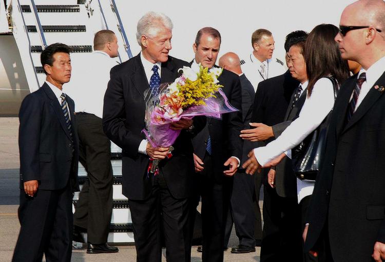 Ekspræsident Bill Clinton, da han forlader den nordkoreanske hovedstad med de to frigivne journalister.  Billedet er fra det officielle nordkoreanske nyhedsbureau. 