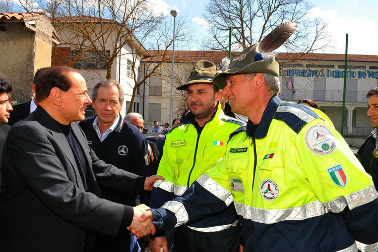 Silvio Berlusconi hilser på nogle redningsarbejdere i forbindelse med jordskælvet i Italien 7. april. (Arkivfoto) 