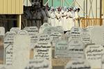 Kuwaitiske mænd beder for de døde kvinder og børn før begravelsesceremonien søndag i provinsen Jahra. 