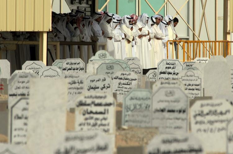 Kuwaitiske mænd beder for de døde kvinder og børn før begravelsesceremonien søndag i provinsen Jahra. 