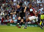 Manchester Uniteds Wayne Rooney forsøger at liste et skud forbi Burnleys Clarke Carlisle. 