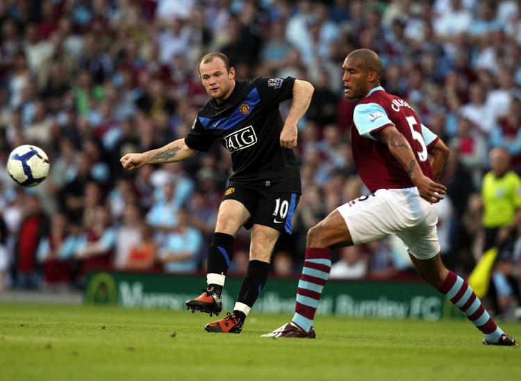 Manchester Uniteds Wayne Rooney forsøger at liste et skud forbi Burnleys Clarke Carlisle. 