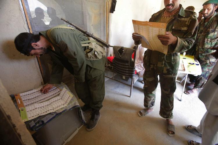 En soldat fra den afaghanske hær afgiver sin stemme på et valgsted i landsbyen Dahaneh i Helmand-provinsen. 