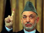 Afghanistans præsident Hamid Karzai viser sin blækfarvede pegefinger, efter at han havde stemt i går. 