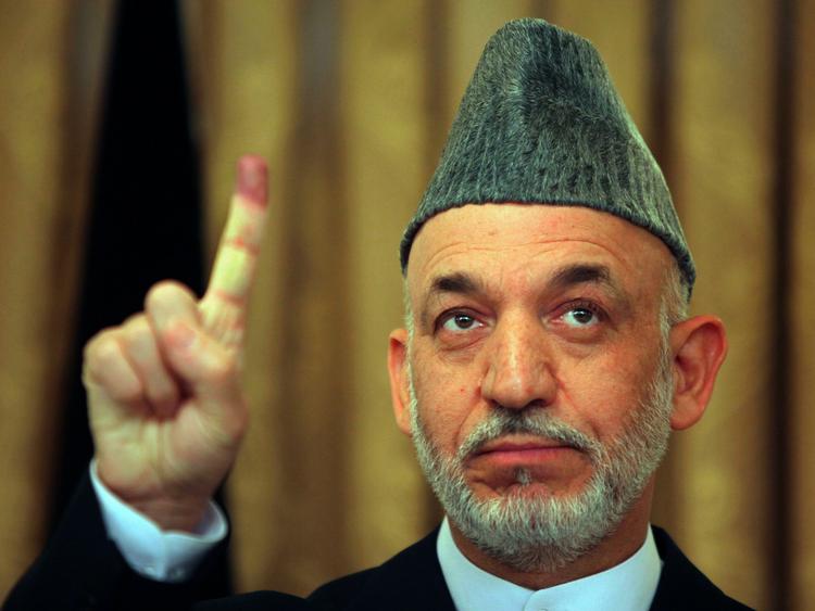 Afghanistans præsident Hamid Karzai viser sin blækfarvede pegefinger, efter at han havde stemt i går. 