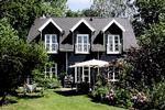 Det sorte træhus med hvide vinduer giver mindelser om klassiske nordsjællandske sommerhuse. 