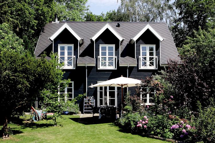 Det sorte træhus med hvide vinduer giver mindelser om klassiske nordsjællandske sommerhuse. 