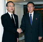 Sydkoreas minister for forening,  Hyun In-taek (til venstre) trykker hænder med Nordkoreas spionchef Kim Yang Gon. I morgen mødes nordkoreanerne med Sydkoreas præsident. 
