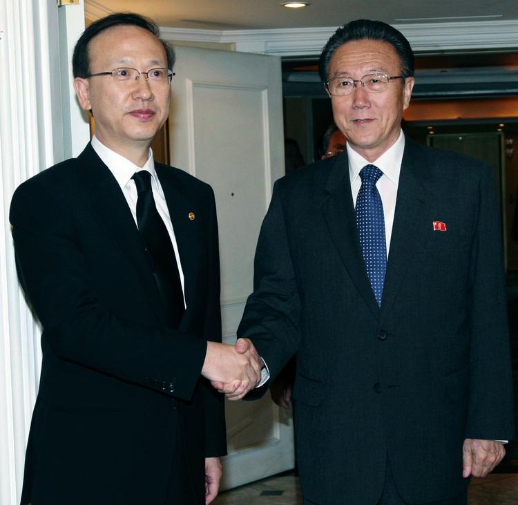 Sydkoreas minister for forening,  Hyun In-taek (til venstre) trykker hænder med Nordkoreas spionchef Kim Yang Gon. I morgen mødes nordkoreanerne med Sydkoreas præsident. 