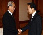 Sydkoreas præsident Lee Myung-bak (til højre) giver hånd til chefen for den nordkoreanske delegation Kim Ki Nam. 