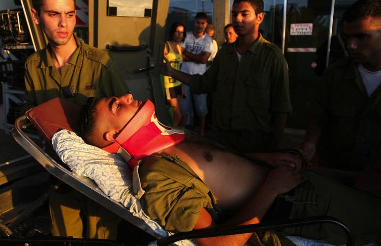 Et såret israelsk soldat køres på hospitalet. Han blev såret af en mortergranat, som ramte en strand i Israel. 