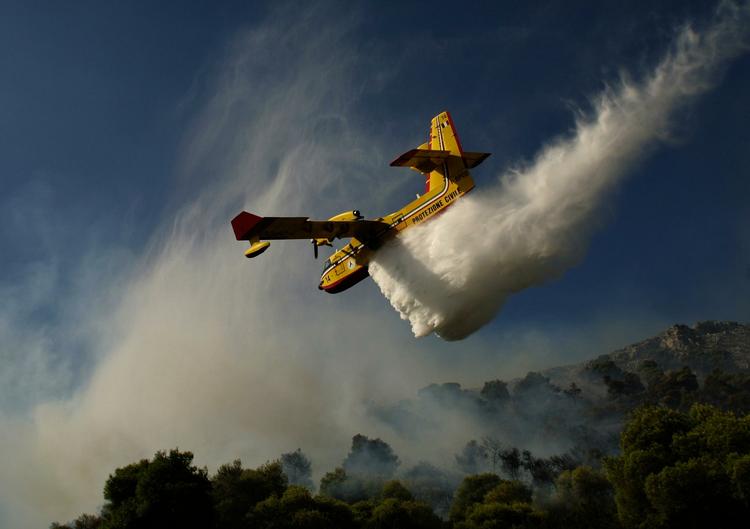 Et fly kaster vand ud over skovbrande nær kystbyen Nea Makri. 