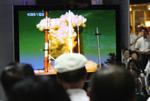 Opsendingen af Sydkoreas førstee rumraket blev sendt på tv og fulgt over hele landet - her har togrejsende samlet sig foran et tv på en banegård i Seoul. 