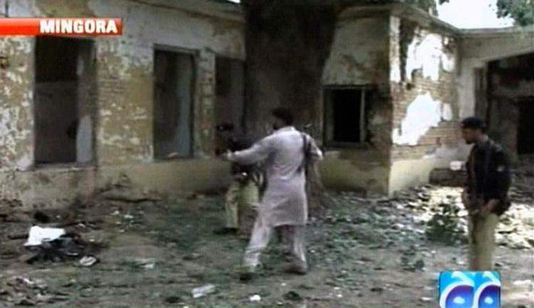 Et billede fra pakistansk tv viser, politibetjente undersøge stedet, hvor 12 af  deres kolleger blev dræbt. 