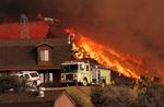 Brandfolk på jorden og i luften kæmper for at redde et hus i Acton i Californien. 