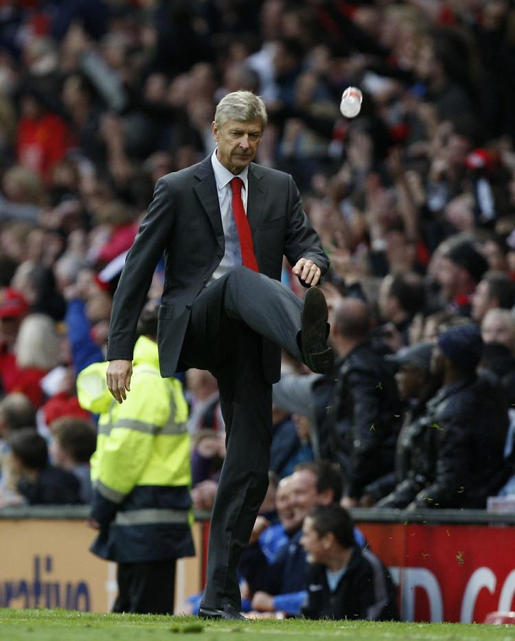 Arsene Wenger forsøger sig med en gakket gangart, da han rammer en vandflaske med et spark, som fik dommeren til at bortvise træneren. Arkivfoto. 