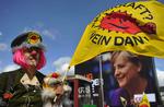 En demonstrant vifter med sit flag med teksten 'Atomkraft - nej tak' foran en valgplakat med  Angela Merkels portræt. 