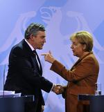 Angela Merkel og Gordon Brown giver hånd til et pressemøde i Berlin søndag. 