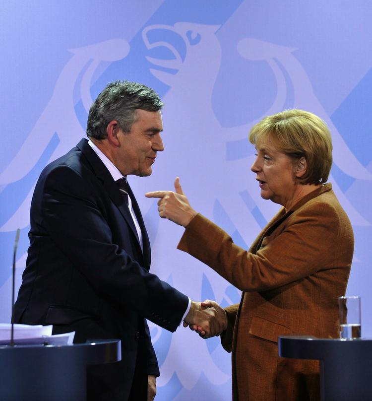 Angela Merkel og Gordon Brown giver hånd til et pressemøde i Berlin søndag. 