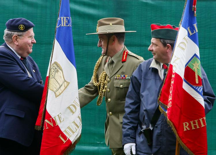 En australsk general give hånd til franske veteraner i Formelles i maj, da udgravningerne af massegraven gik i gang. 