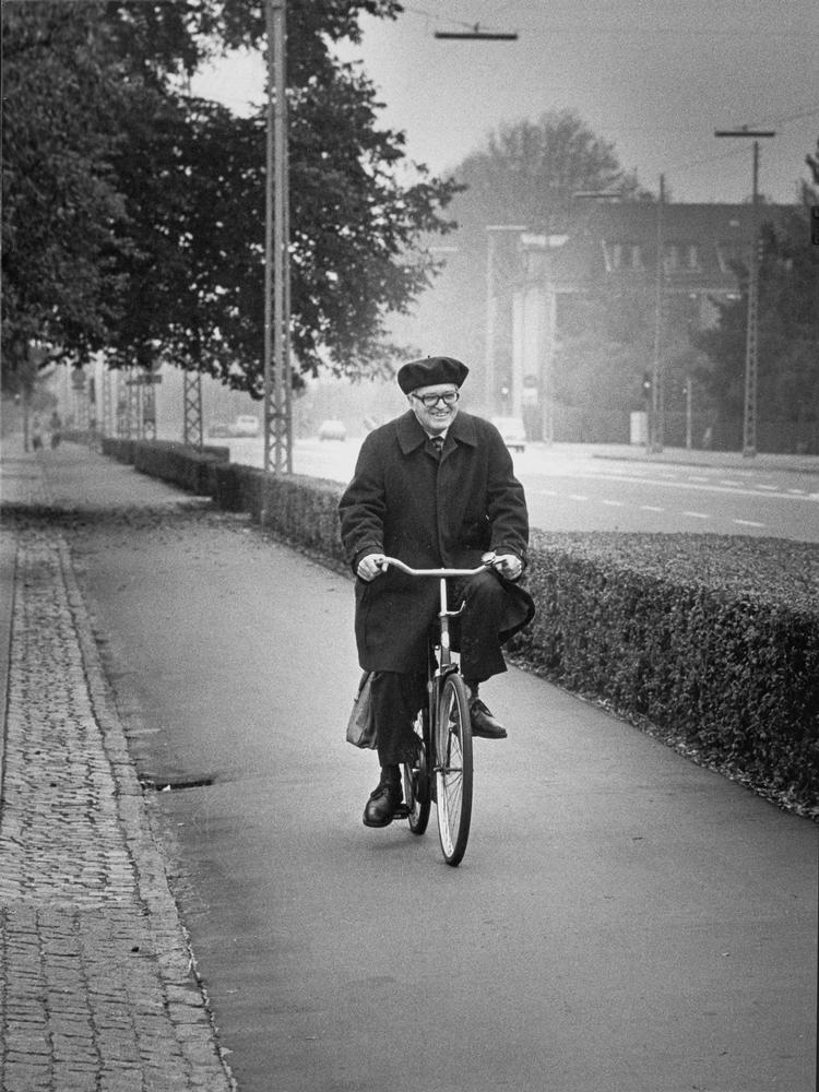 Aage Bohr fotograferet den morgen i 1975, da morgennyhederne lige havde forkyndt, at han  - sammen med sin kollega Ben R. Mottelson - fik Nobelprisen i fysik. Han tager det roligt og cykler til arbejde ad Bernstorffsvej. 