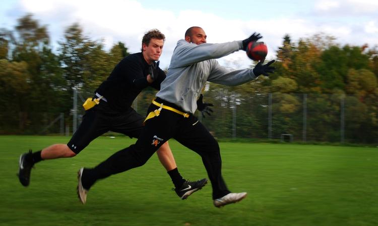 Fysisk kontakt er ikke tilladt i flagfootball. Man tackler i stedet ved at snuppe de gule flag, som sidder på hofterne. Foto: Rasmus Schou 