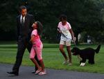 Barack Obama i selskab med  døtrene Sasha og Malia (th) med hunden Bo ved Det Hvide Hus i går. 