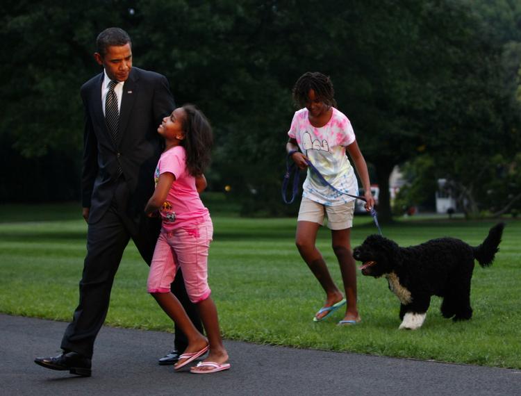 Barack Obama i selskab med  døtrene Sasha og Malia (th) med hunden Bo ved Det Hvide Hus i går. 