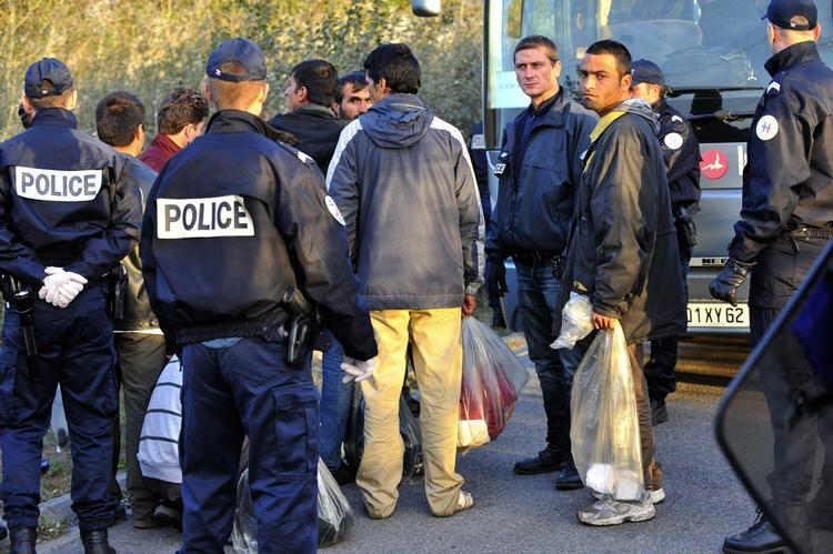 Franske betjente gør klar til at eskortere immigranterne fra den nu fjernede lejr væk. 