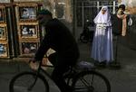 En mand cykler forbi en mannequin, som overholder myndighedernes regler for udstillingsdukker i byen Mashhad i Iran. 