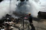 En dreng skubber en indkøbsvogn igennem et af de fattige kvarterer i Honduras' hovedstad, Tegucigalpa, efter voldsomme kampe mellem tilhængere af eks-præsident Zelaya og politiet. En 65-årig mand blev dræbt. 
