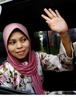 Kartika Sari Dewi Shukarno vinker farvel til sin familie før forrige retsmøde i august. 