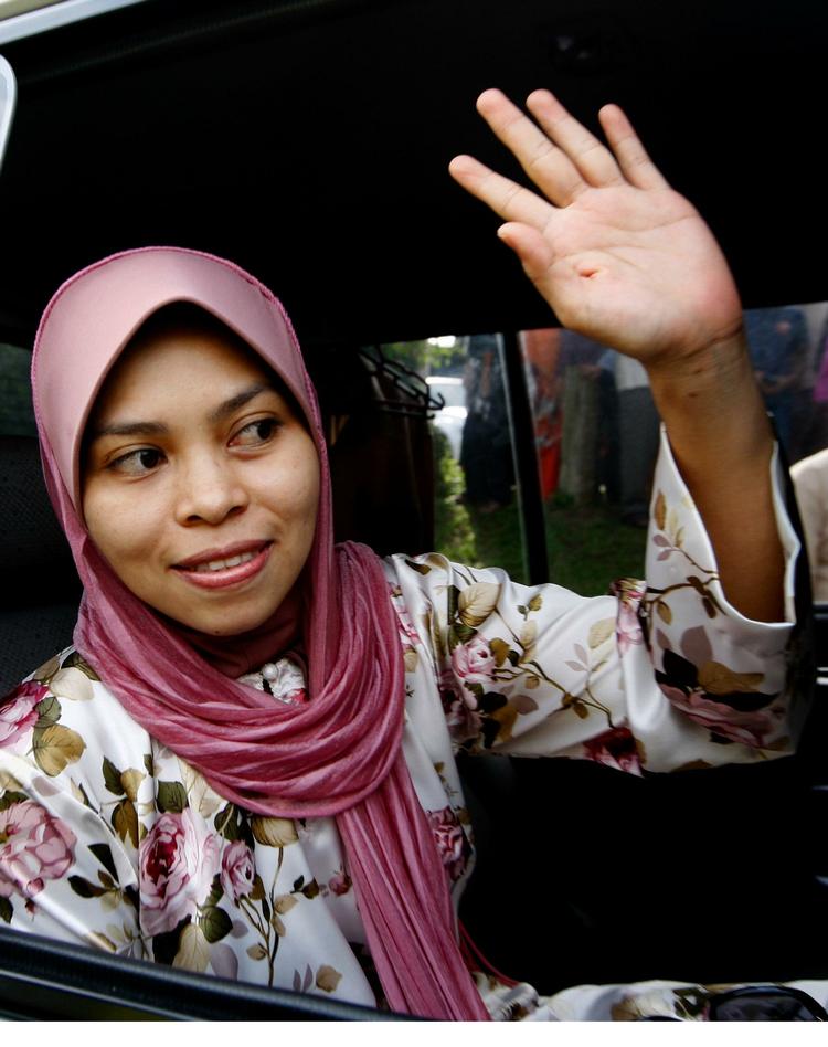 Kartika Sari Dewi Shukarno vinker farvel til sin familie før forrige retsmøde i august. 