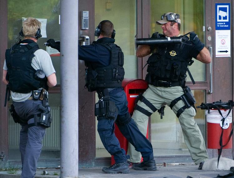 Svenske politifolk brød efter røveriet gennem døren til værdicentralen. (Arkivfoto) 