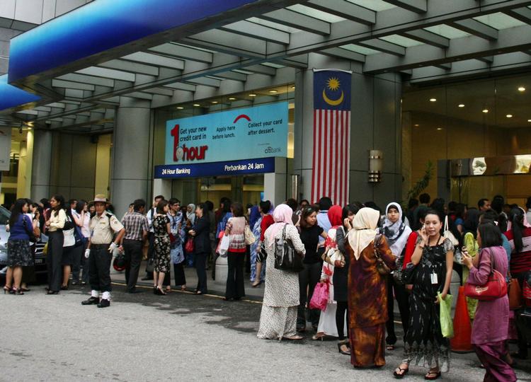 Evakuerede kontorarbejdere venter på at komme tilbage til skrivebordet i Malaysias hovedstad Kuala Lumpur. 