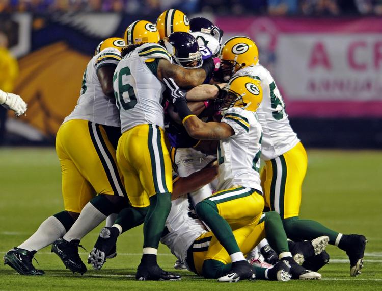 Stakkels Adrian Peterson er noget i undertal omgivet af seks Green Bay Packers-spillere. 